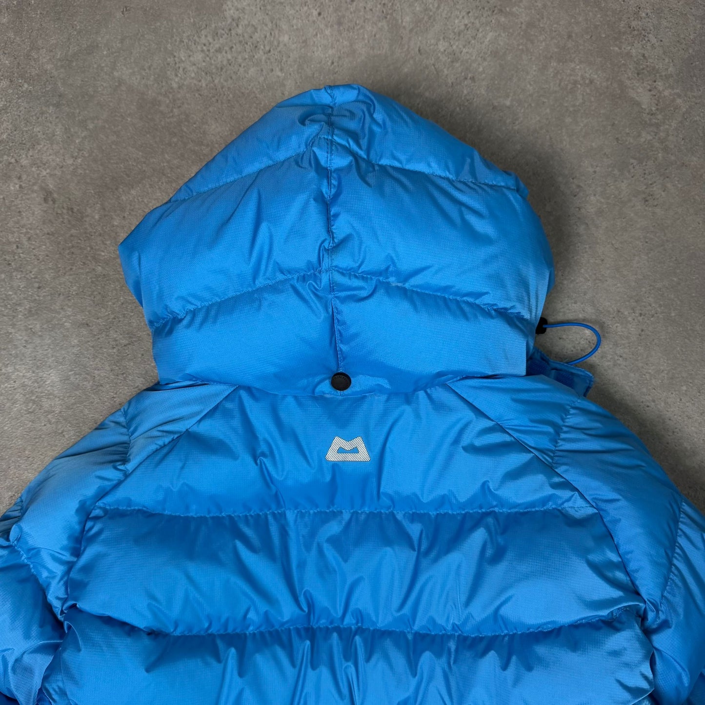 Women's mountain equipment puffer jacket with hood in blue - XS